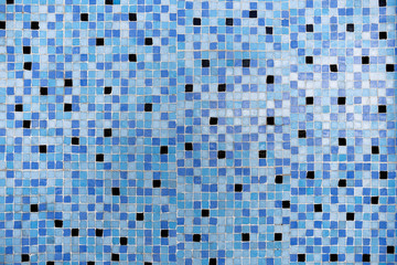 Blaues, älteres Mosaik aus kleinen, viereckigen, hellblauen und dunkelblauen Fliesen