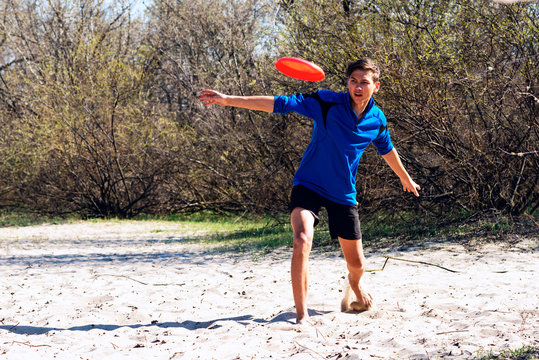 Focused Teenage Boy Is Enthusiastically Throwing Frisbee