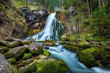 Idyllic waterfall scene with mossy rocks in the forest