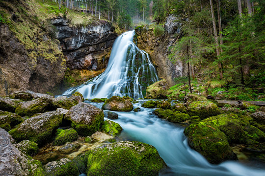 Fototapeta Idyllic waterfall scene with mossy rocks in the forest