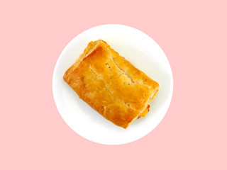 single rectangle chicken pie on white ceramic dish isolated on pastel pink