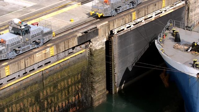 Trains pulling a oil tanker ship through the locks in Gatun Panama.