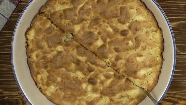 Hand with knife cutting appe pie