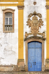 Fototapeta na wymiar Old withe and yellow catholic church facade of the 18th century located in the center of the famous and historical city of Ouro Preto in Minas Gerais