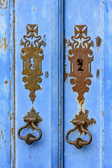 Old and aged blue historic church wooden door in the city of Ouro Preto, Minas Gerais with its rusty metal part.