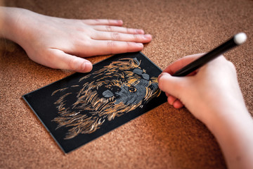 The girl scrabbles a black picture to get a gold image of a dog