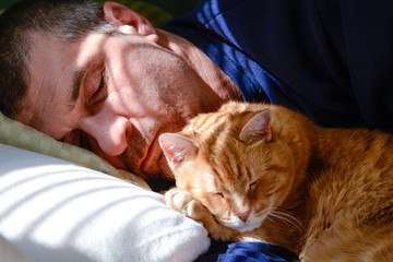 Best friends, man and cat take a nap