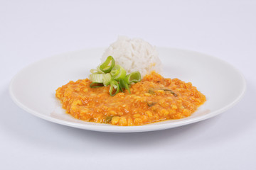 Red lentil in a sauce ansd rice on a white
