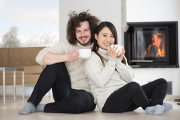 Fototapeta na wymiar happy multiethnic couple in front of fireplace