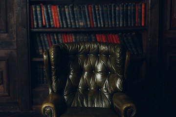 Vintage leather green chair and bookcase in the office