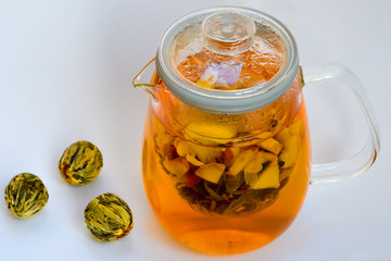 Green tea with ginger and spices. In a transparent teapot. Healthy eating. With three balls of green tea