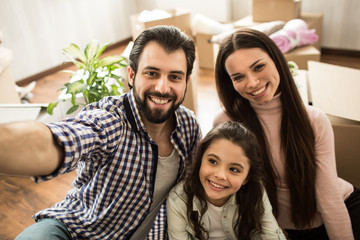Fototapeta premium Selfie of happy family. They are looking on the camera and smiling. This family is very beautiful.