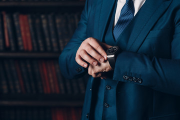 Businessman in a luxury suit looks at the clock