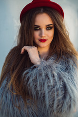 Portrait of a girl with long hair, red lips and a hat
