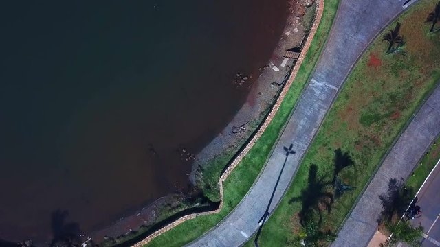 Aerial bird's eye view flying across the shore of Lake Paranoa in Brasilia near the Juscelino Kubitschek Bridge