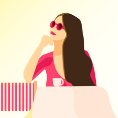 Girl is sitting at the table in the cafe and drinking coffee