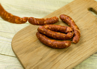 Smoked natural sausages   on a wooden surface.