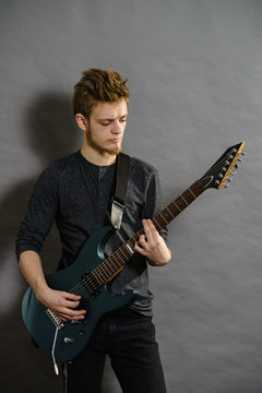Young man playing electric guitar