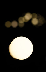 Soft bokeh background.  Garland of electric lights. Place to add text. Blurry abstraction. Black & white. Dark night. Festive party in city. Soft focus effect.