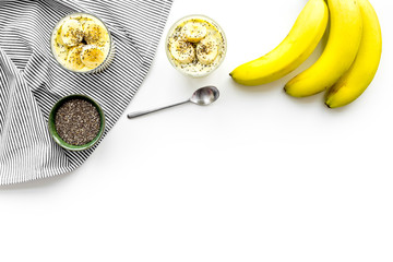 Light healthy snack. Banana pudding with chia seeds on white table with blue tablecloth top view space for text