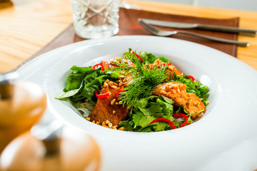 Baked fish dressed with sauce and fresh herbs