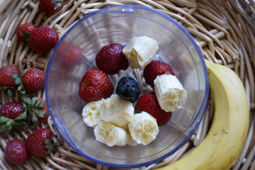 Ingredients for smoothies in blender. Bananas and strawberries