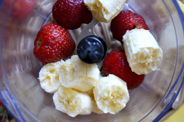 Ingredients for smoothies in blender. Bananas and strawberries