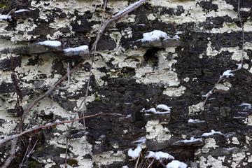 Cracked shale wall with ice and snow. 