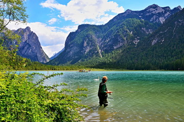 Fototapeta na wymiar Italian Dolomites - fisherman in the lake Toblachersee