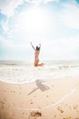 Obraz na płótnie Canvas A girl is jumping on the beach.