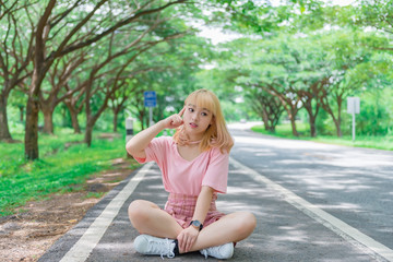 Naklejka na ściany i meble Portrait of beautiful asian girl golden hair with camera,Thailand people in pink dress,hipster girl