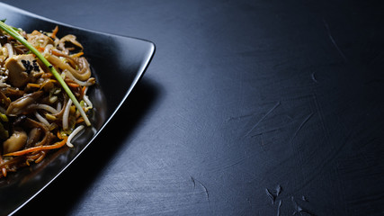 oriental cuisine food. wholesome healthy eating. vegetable salad on dark background . copyspace concept