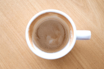 Top view image of finished cup of coffee on wooden table in cafe