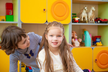 Offended girl tries to console another girl. one little girl looks in the face of another