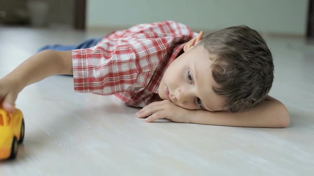 sad little boy lying on the floor at home  at the day time