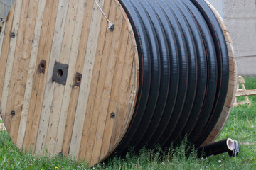 Large polyethylene pipes in the coil for gas and water are liyng on the ground.