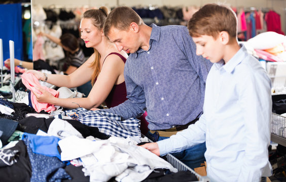 Mother,father and son choosing wear at the clearance sale shop
