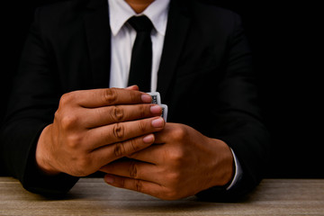 Obraz premium Gambling Concepts. Businessmen are gambling in the casino. Betting is a gamble for investors. Businessmen are playing card games on a black background.