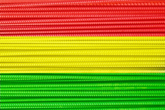 Red yellow & green tricolor flag. Metal reinforcement bars w/ periodic profile texture. New iron rod w/o rust, steel construction armature pile. Rasta strength concept. Copy space, close up background