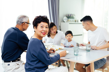 Happy Asian extended family having dinner at home full of happiness and smiles