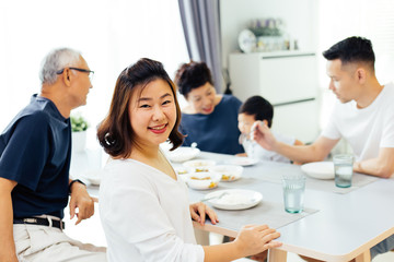 Happy Asian extended family having dinner at home full of happiness and smiles