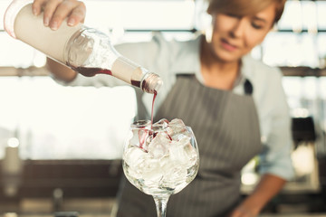 Experienced barista doing alcohol cocktail in cafe