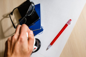 Man makes the stamp using sealing wax with glasses and pen