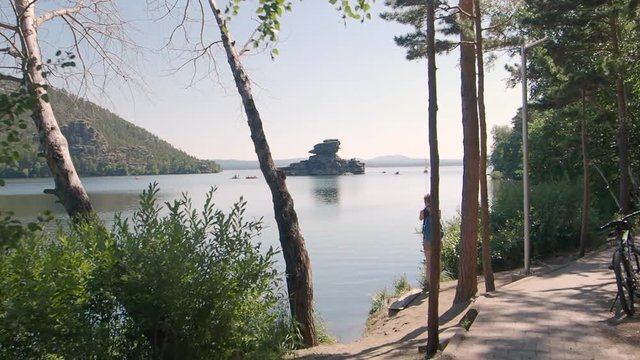 Tourist taking pictures at Lake Borovoe in Kazakhstan on summer vacation