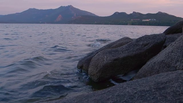 Sunset by peaceful rocky of lake in Kazakhstan