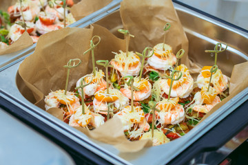 Hot Delicates, appetizer canape with tiger shrimp, fused cheese and vegetables. Catering service.