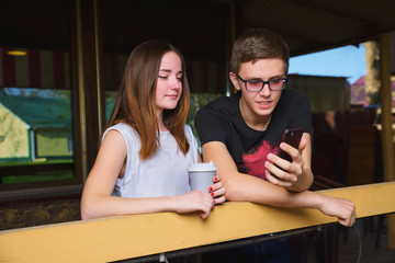 A guy with a girl in the Park and on the street with gadgets spend time together