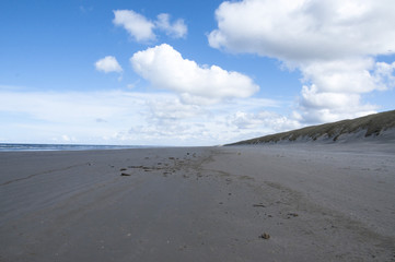 Strand mit Wolken und blauem Himmer