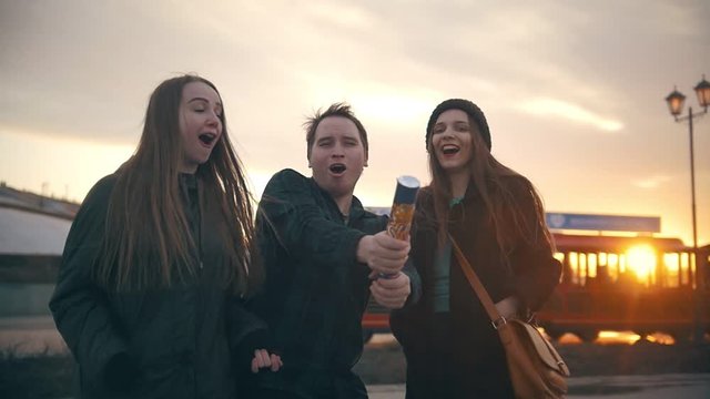Failure - cheerful friends having fun with party poppers confetti at sunset outdoors