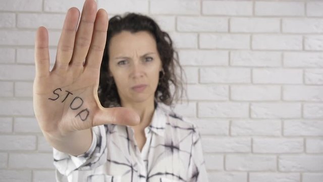 Domestic violence. A woman shows an inscription on the palms of the STOP.